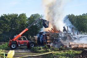 Ein Radlader der Feuerwehr Iserlohn unterstützt bei den Löschmaßnahmen.